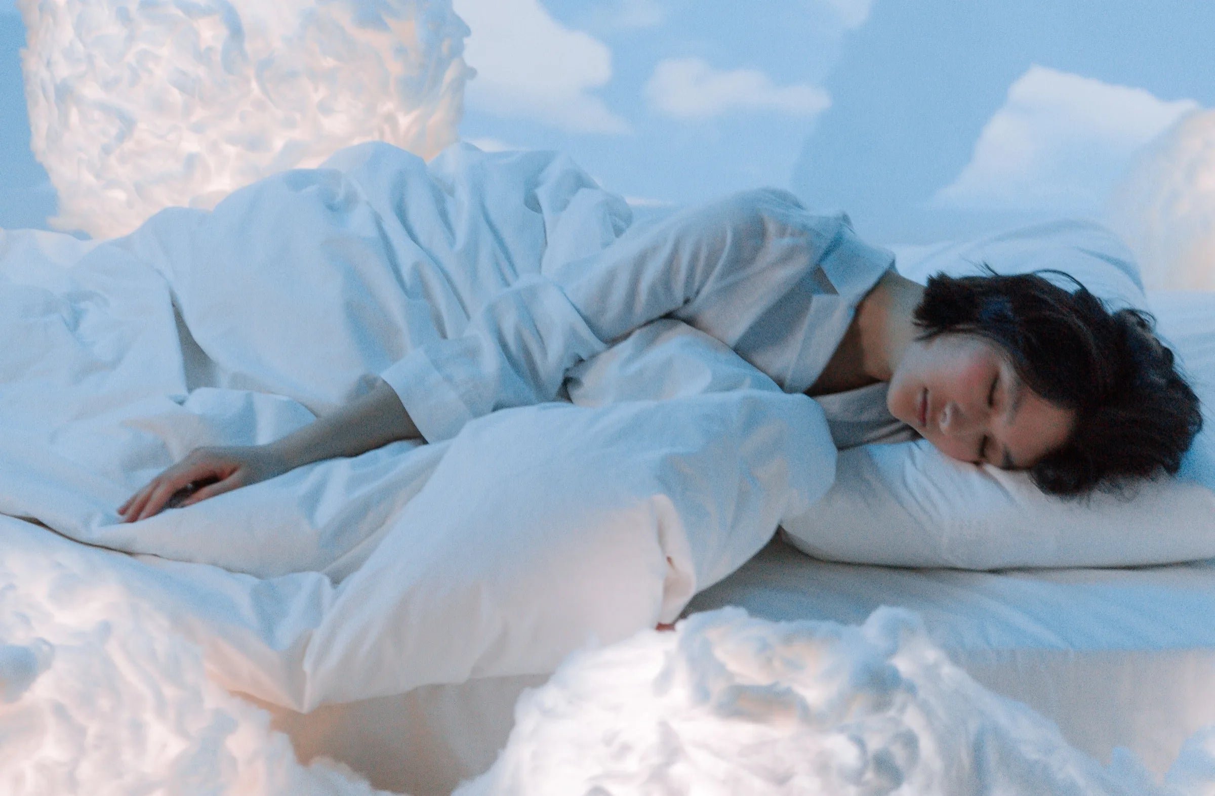 A person asleep in white bedding